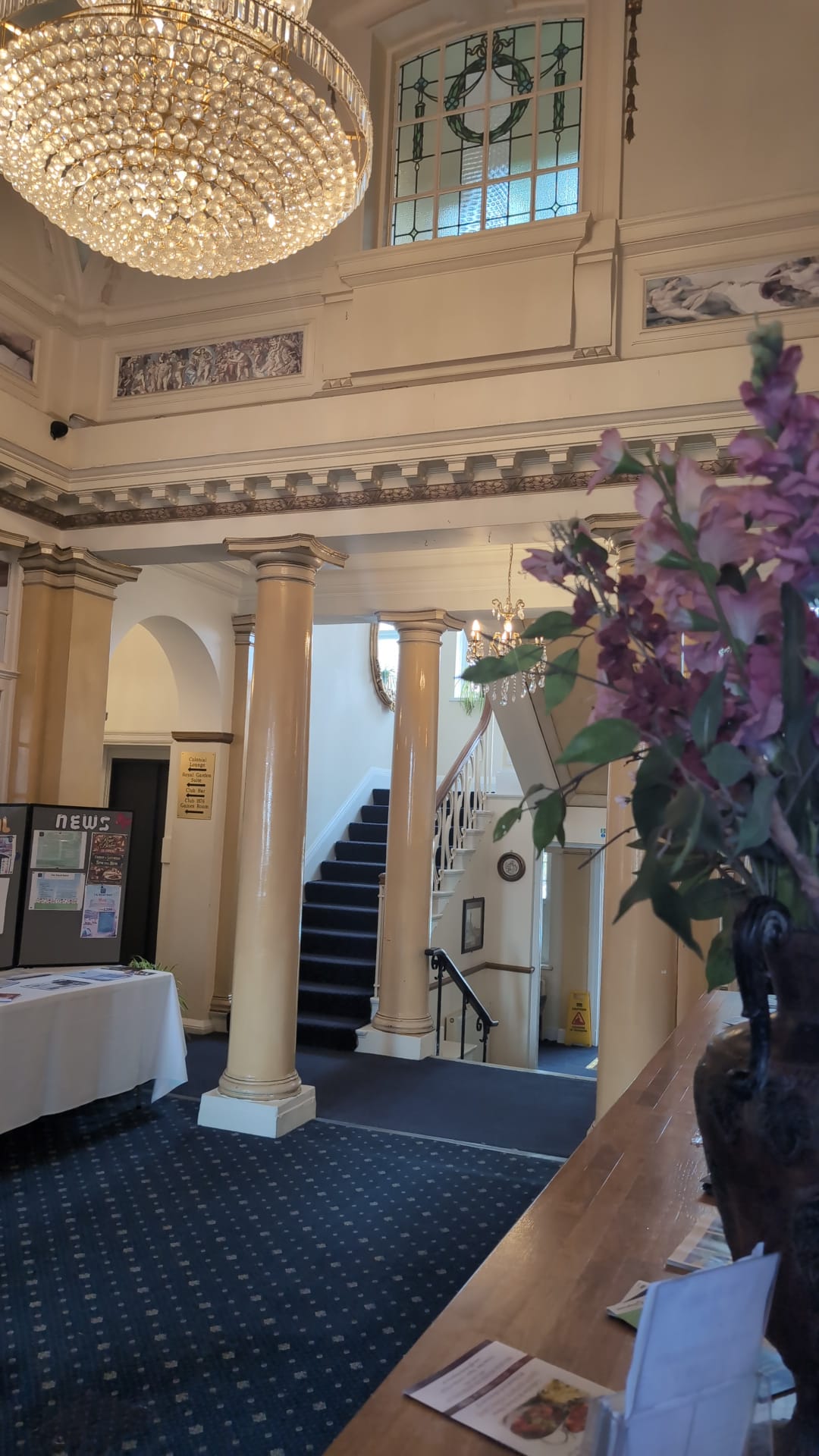 Reception lobby with stairs and floral arrangement