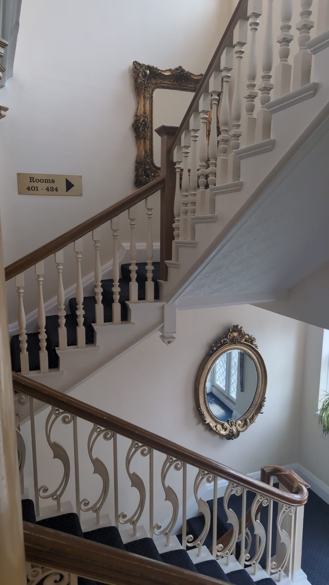 Grand staircase with ornate mirror on the landing