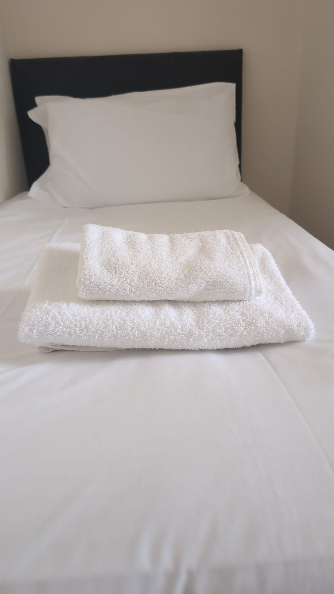 Folded towels on the single bed